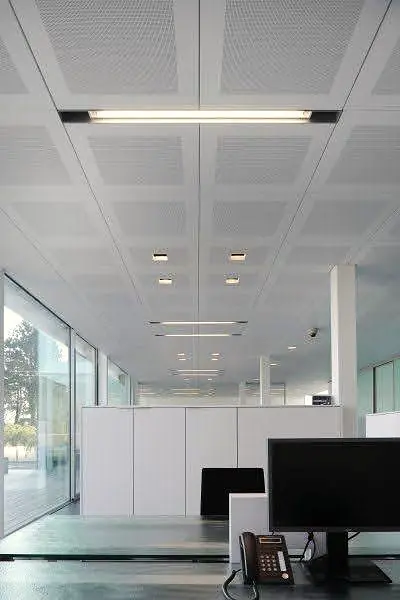 Office with a perforated grid ceiling and slim linear lights