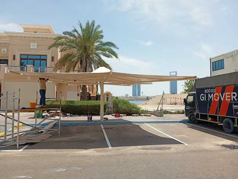 Team installing a fabric car park shade outside a villa