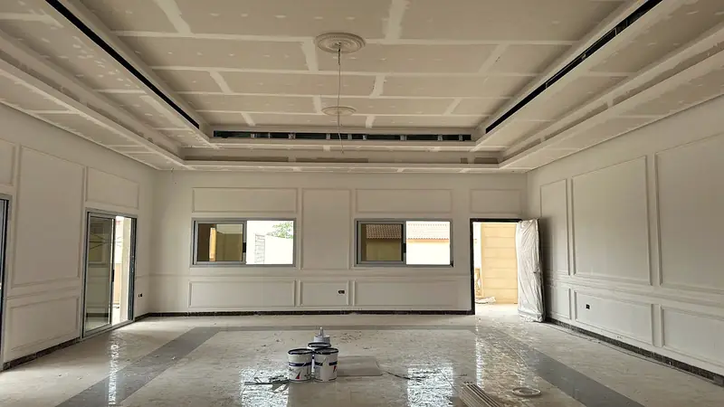 Hall with a stepped gypsum ceiling, ceiling roses and panel mouldings on every wall